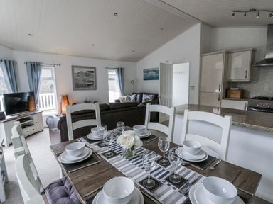 A dining room with a table set for dinner at Seacroft in Stepaside near Kilgetty