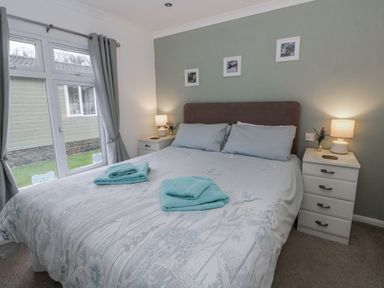 A bedroom with a double bed and bedside table at Seacroft near Kilgetty