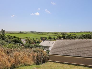 Green fields and houses with tiled roofs under a blue sky at 2 Sunny Hill in Porthgain near St Davids