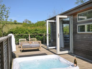An outdoor area with a hot tub and seating at 7 Valley View, Lanreath