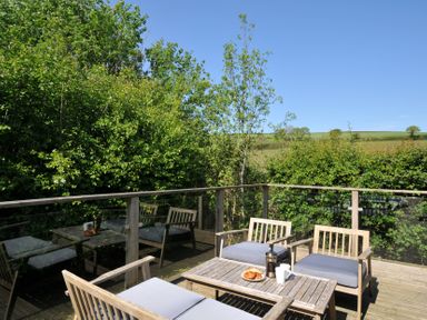 An outdoor seating area with a table and chairs at 7 Valley View in Lanreath
