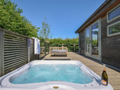 An outdoor area with a hot tub and champagne at 7 Valley View in Lanreath