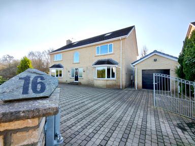 Front view of a two-story house with a paved driveway and detached garage at Sanderson House in Cleator Moor