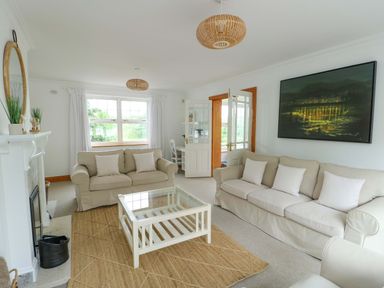 A living room with a sofa and coffee table at Bwthyn Clai in Llangefni