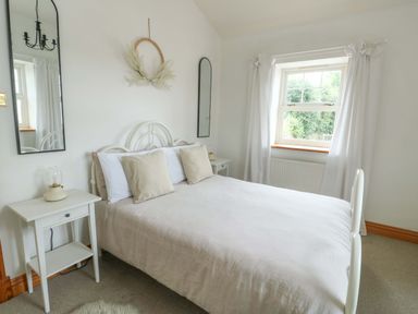 A bedroom with a bed and bedside table at Bwthyn Clai in Llangefni