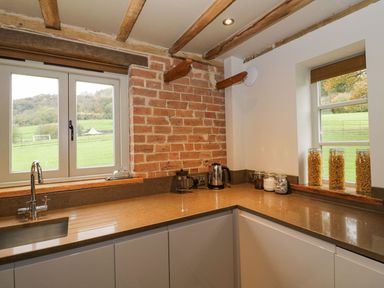 A kitchen corner with a sink kettle jars of pasta and wooden beams on the ceiling at Fairoaks Barns in Hollybush near Ledbury