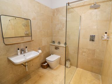 A bathroom with a sink mirror toilet and shower at Fairoaks Barns in Hollybush near Ledbury