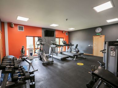 A gym room with treadmills dumbbells exercise machines and a rowing machine at Mallard Cottage in Penrith