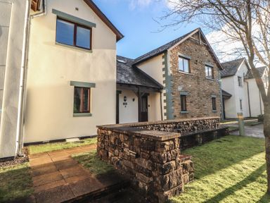 A house exterior with a stone wall and pathway at Mallard Cottage Penrith