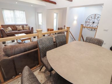 A living room with a sofa and dining table at Mallard Cottage in Penrith