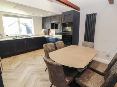 A kitchen with a table and chairs at Mallard Cottage in Penrith