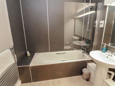 A bathroom with a bathtub, sink, and toilet at Mallard Cottage in Penrith