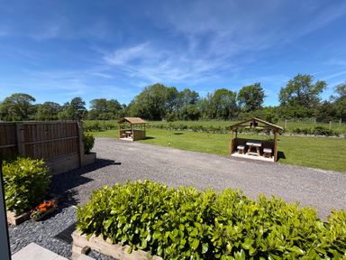 A garden with wooden shelters and a gravel path at No Deer in Ashbourne