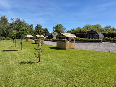An outdoor area with huts and grass at No Deer Ashbourne