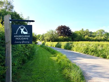A sign for Ashbourne Holidays near the road in Ashbourne