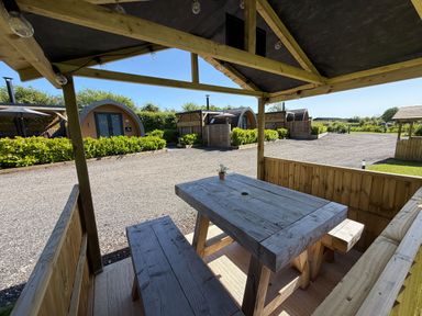 An outdoor seating area with a table and benches at No Deer in Ashbourne
