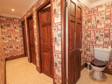 A hallway with multiple wooden doors and a toilet visible in one open door at Highcliffe Manor in Flamborough