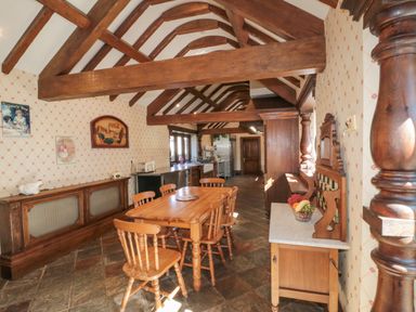A dining room with wooden table and chairs under exposed wooden beams at Highcliffe Manor in Flamborough