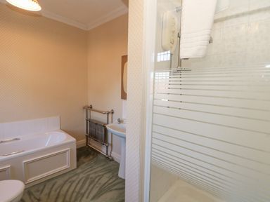 A bathroom with a bathtub sink radiator and shower at Highcliffe Manor in Flamborough