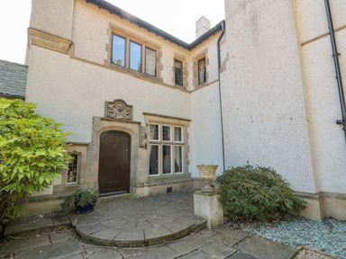 An exterior view of a building entrance with a dark wooden door and surrounding stonework at Highcliffe Manor in Flamborough
