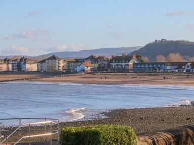 A beachfront with buildings and hills in the background at The Outlook in Minehead
