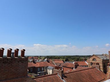 A view of rooftops with chimneys and a clear sky at Skylark in Southwold