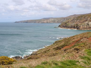 A coastal landscape with cliffs and ocean waves at Ramblers Rest in St Just