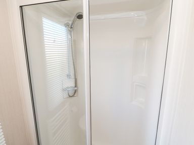 A shower enclosure with a handheld showerhead and built-in shelves at 17 Summer Meadows in Ashington