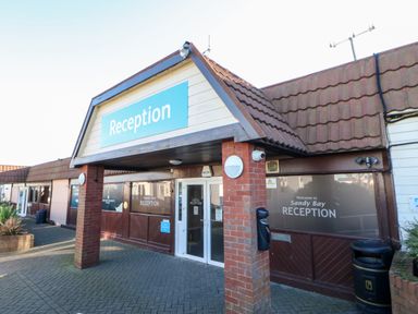 The exterior entrance with a reception sign on a building at Sandy Bay in Ashington