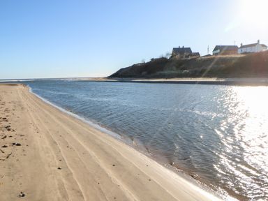A sandy beach with a body of water beside houses on a hill at 17 Summer Meadows in Ashington