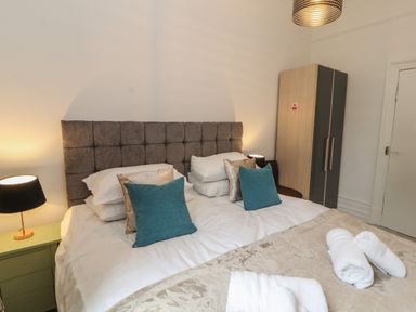 A bedroom with a double bed with pillows and towels on at The Furness Haven in Barrow-In-Furness