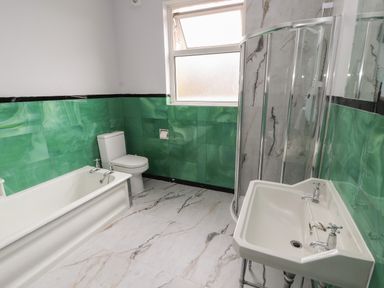 A bathroom with a bathtub toilet sink and shower at The Furness Haven in Barrow-In-Furness