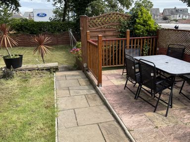 A garden with a table and chairs at The Furness Haven in Barrow-In-Furness