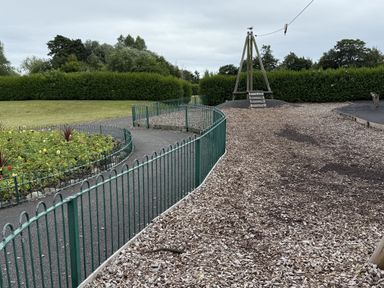 A playground area with a slide and a flower bed at The Furness Haven Barrow-In-Furness