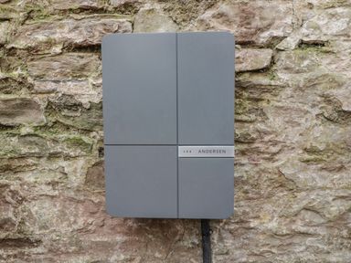 A gray square electrical box mounted on a stone wall at Belle Vue in Hay on Wye Herefordshire