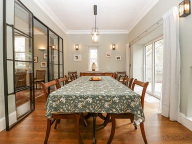 A dining room with a long table covered with a patterned tablecloth surrounded by chairs at Belle Vue in Hay on Wye Herefordshire