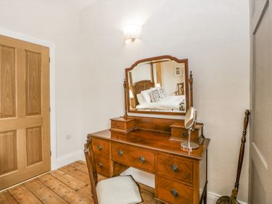A wooden dressing table with a mirror and a chair in a room at Belle Vue in Hay on Wye Herefordshire