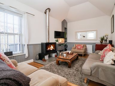A living room with a fireplace a wooden coffee table sofas and an armchair at Ebenezer Chapel in Knodishall nr Saxmundham