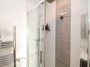 A bathroom with a glass shower enclosure a towel rack and a toilet paper holder at Ebenezer Chapel in Knodishall nr Saxmundham