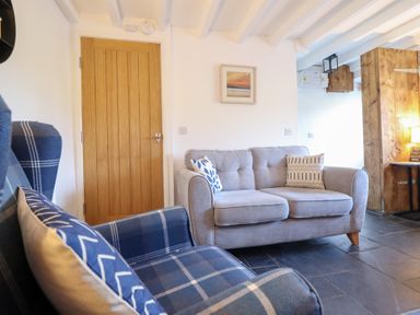 A living room with a sofa and armchair at Ael Y Bryn in Ffestiniog
