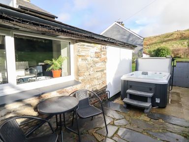An outdoor area with a hot tub and seating at Ael Y Bryn Ffestiniog