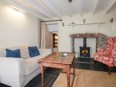 A living room with a sofa and fireplace at Penvar in Truro