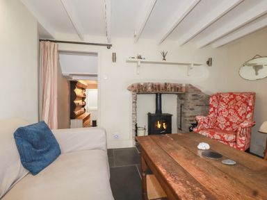 A living room with a fireplace and seating area at Penvar in Truro