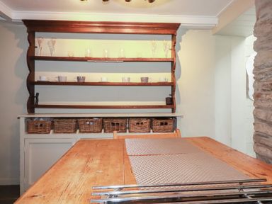 A kitchen with shelves and a wooden table at Penvar in Truro
