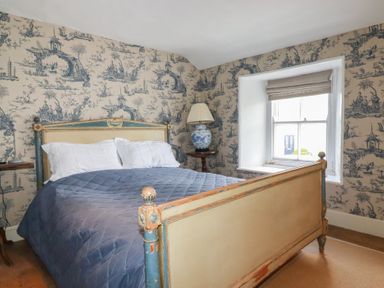 A bedroom with a bed and side table at Penvar in Truro