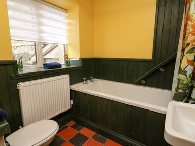 A bathroom with a bathtub toilet window and sink at Cringoed House Llanarth near Aberaeron