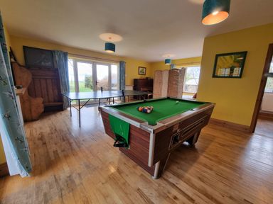 A recreation room with a pool table and ping pong table near windows at Cringoed House Llanarth near Aberaeron