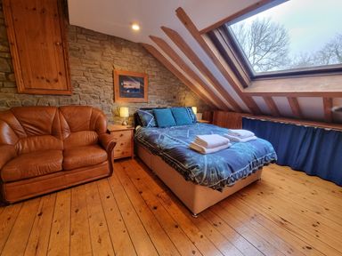 A bedroom with a bed and bedside tables under a skylight at Cringoed House Llanarth near Aberaeron