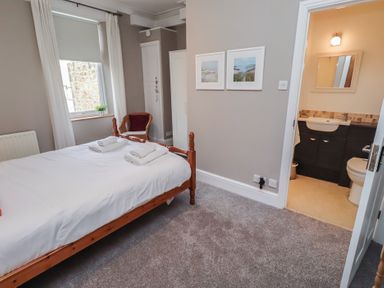 A bedroom with a bed and an attached bathroom at Rose House in Alnmouth