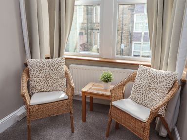 A sitting room with two chairs and a small table at Rose House Alnmouth
